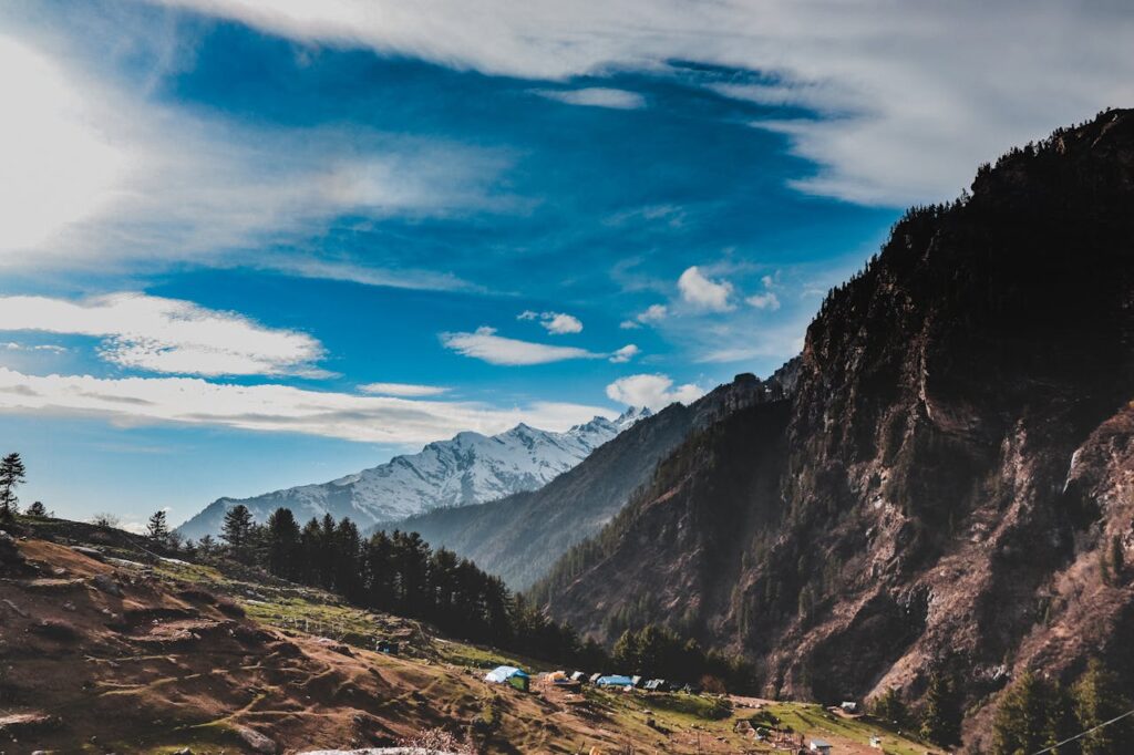 Breathtaking view of the Himalayan mountains in Himachal Pradesh, showcasing lush green forests and clear skies.