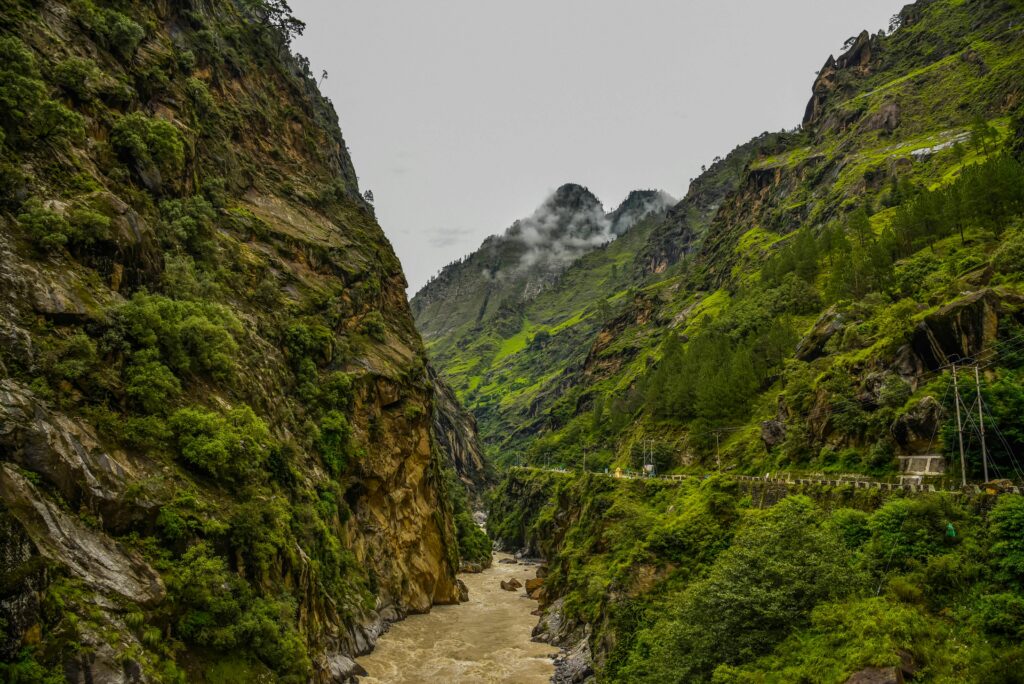A breathtaking view of lush green mountains and a winding river in Himachal Pradesh, India.