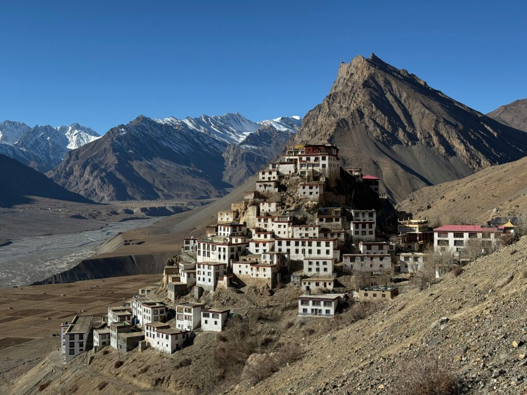 Scenic view of Key Monastery nestled in the rugged mountains of Spiti Valley under clear blue skies.